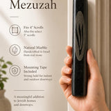 Person naturally holding the black marble mezuzah showing its size, texture, and craftsmanship for a premium product display.