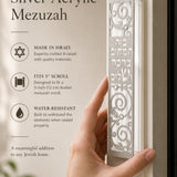 Person naturally holding the Blessings of Peace Silver Acrylic Mezuzah with warm lighting and elegant composition, emphasizing product details.