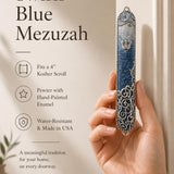 Female hand presenting the Elegant Swirls Blue Mezuzah in a premium store display setting.