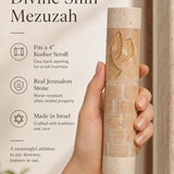 Hand holding the 5-inch Divine Shin cream Jerusalem stone mezuzah, showing the gold shin detail.