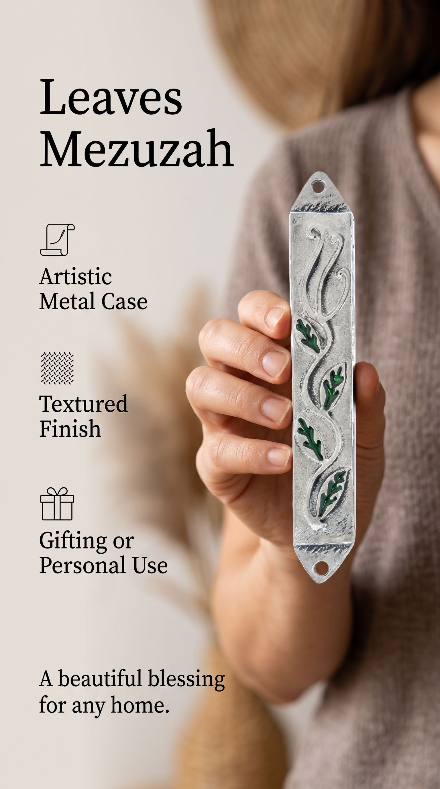 Person holding a botanical style leaves mezuzah case made from pewter and hand painted green enamel.