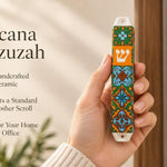Close-up of a person holding the artisanal ceramic Toscana Mezuzah decorated with orange, deep green, and pale blue tile patterns.