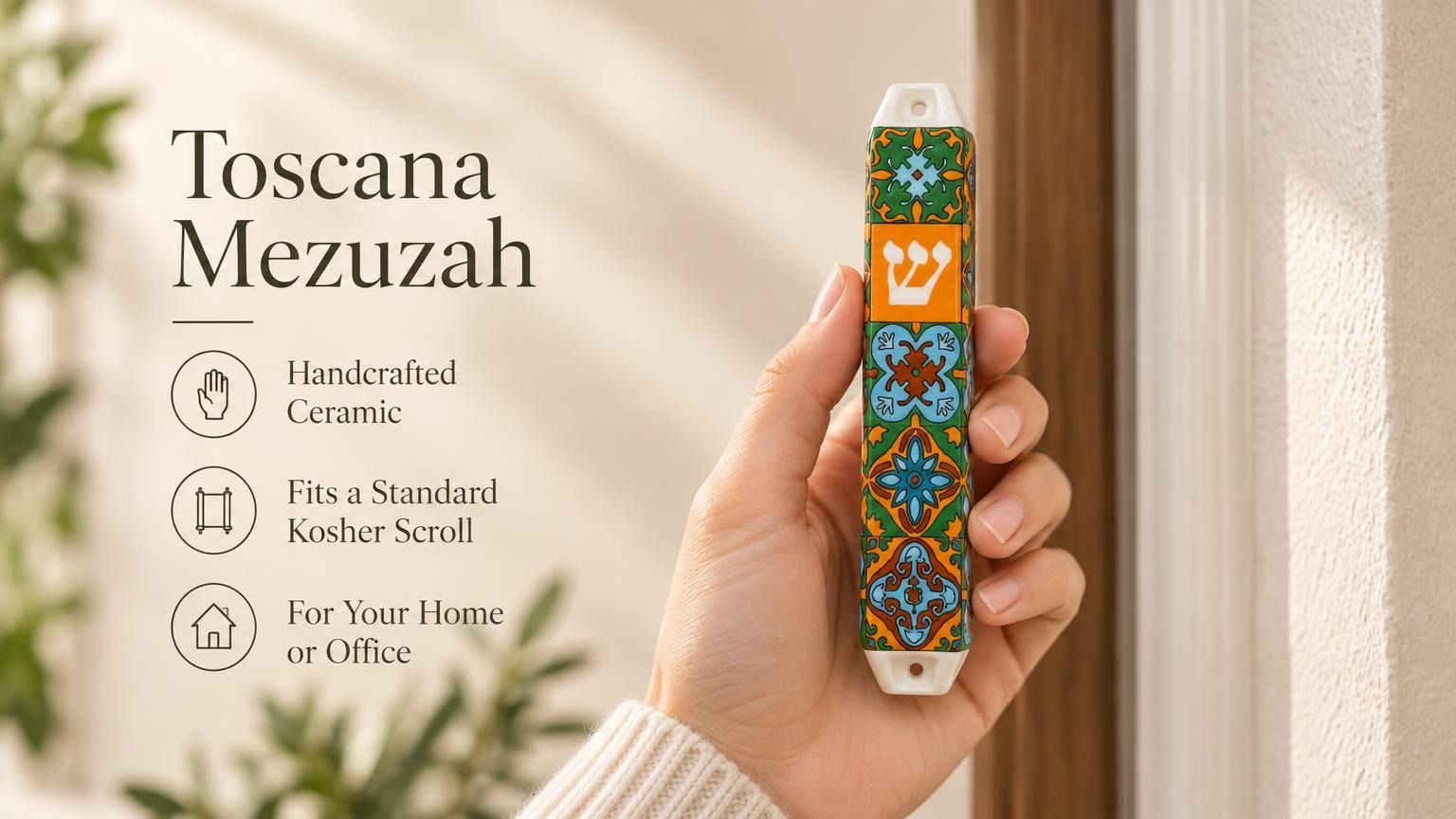 Close-up of a person holding the artisanal ceramic Toscana Mezuzah decorated with orange, deep green, and pale blue tile patterns.