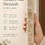 Hand holding the Kotel extra large cream stone mezuzah, showing the carved stone courses and texture.