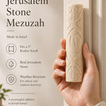 Person holding the authentic Jerusalem stone mezuzah, showcasing its carved leaf motif and natural cream color.