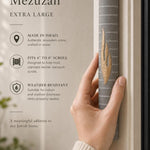 Hand holding the Yerushalayim gray and gold Jerusalem stone mezuzah showing its finish.