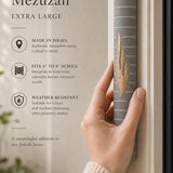 Hand holding the Yerushalayim gray and gold Jerusalem stone mezuzah showing its finish.