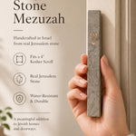 Person naturally holding the handcrafted gray Jerusalem stone mezuzah, showcasing its texture and size in a premium style.