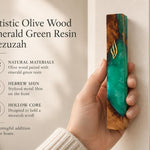 Person holding an artistic olive wood and emerald green resin mezuzah case with a gold-toned Shin letter for a Jewish home.