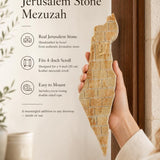 Person holding a large cream colored Jerusalem stone mezuzah with gold Hebrew Eretz Yisrael lettering and detailing.
