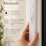 Large white acrylic mezuzah cover mounted vertically on a front doorpost, showing its slim seven-inch profile and sculpted silver Shin