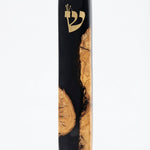 Healing black Mezuzah made of olive wood and resin, with intricate Hebrew engravings, mounted on a white studio background with soft reflection.