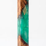 Artistic Olive Wood Emerald Green Resin Mezuzah standing on a white studio background, a handmade Israeli mezuzah case pairing warm olive wood grain with translucent emerald green resin and a gold Shin, made for a 6-inch kosher scroll