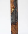 Artistic Olive Wood Charcoal Black Resin Mezuzah standing on a soft gray studio background, a handcrafted mezuzah case made in Israel where dark charcoal resin swirls through natural olive wood beneath a gold Shin, made for a 6-inch kosher scroll
