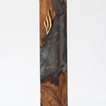 Artistic Olive Wood Charcoal Black Resin Mezuzah standing on a soft gray studio background, a handcrafted mezuzah case made in Israel where dark charcoal resin swirls through natural olive wood beneath a gold Shin, made for a 6-inch kosher scroll