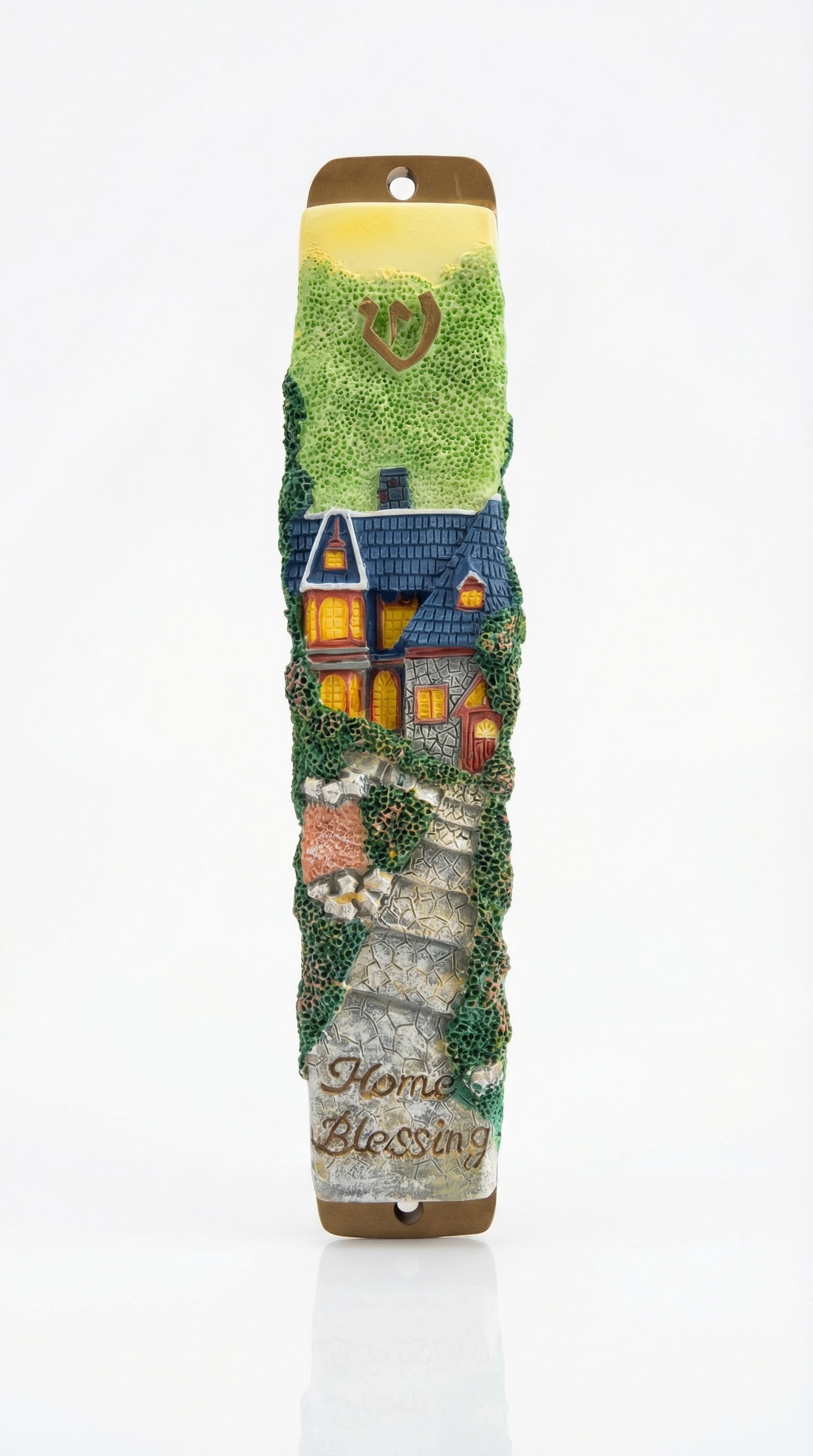 Detailed mezuzah with engraved Hebrew letters and decorative motifs on a white studio background with soft reflection.