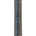 Blue pewter mezuzah with intricate Hebrew script and decorative motifs, displayed on a polished white studio surface with soft reflection.