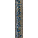 Blue pewter mezuzah with intricate Hebrew script and decorative motifs, displayed on a polished white studio surface with soft reflection.