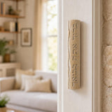 Real Jerusalem stone mezuzah mounted on a doorpost in an indoor setting, showcasing its natural cream color and Hebrew blessing inscription.