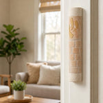 Five-inch Divine Shin stone mezuzah mounted vertically on the upper third of a doorpost.