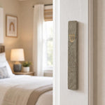 Real Jerusalem stone gray and gold mezuzah mounted on a doorframe in an indoor setting, positioned on the right side of the doorpost.