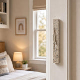 Real Jerusalem stone mezuzah mounted vertically on a residential doorpost at entrance, positioned within upper third for authentic setting.