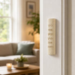 Indoor lifestyle scene showing Jerusalem stone mezuzah mounted on a residential doorpost from an approach perspective, natural lighting.