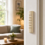 Indoor lifestyle scene showing Jerusalem stone mezuzah mounted on a residential doorpost from an approach perspective, natural lighting.