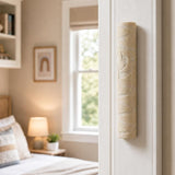 Real Jerusalem stone mezuzah mounted on a residential doorpost, positioned on the right, within the lower third, in a natural indoor doorway scene.