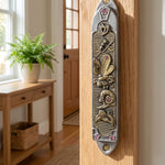 Realistic indoor scene showing a Garden Jewel Pewter Mezuzah mounted on a doorway, in a warm, inviting home environment.