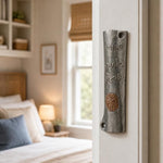 Realistic indoor scene showing the specified ancient Judean coin mezuzah mounted on a residential doorpost at true-to-life scale.