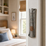Realistic indoor scene showing the specified ancient Judean coin mezuzah mounted on a residential doorpost at true-to-life scale.