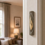 Hyper-realistic indoor scene showing the gray Jerusalem stone mezuzah mounted vertically on a residential doorpost, positioned in the lower third near the edge.