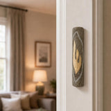 Hyper-realistic indoor scene showing the gray Jerusalem stone mezuzah mounted vertically on a residential doorpost, positioned in the lower third near the edge.