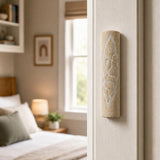 Real Jerusalem stone mezuzah mounted vertically on doorpost in a home's entrance showing natural texture and color variation.