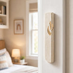 Realistic indoor scene showing Jerusalem stone mezuzah mounted on right doorpost of a residential entryway.