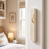 Realistic indoor scene showing Jerusalem stone mezuzah mounted on right doorpost of a residential entryway.