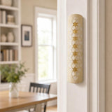 Real Jerusalem stone mezuzah mounted on a residential doorpost in a natural indoor setting, showcasing its handcrafted design and natural surface characteristics.