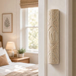 Real Jerusalem stone mezuzah mounted vertically on a residential doorpost in a natural indoor setting.