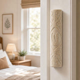 Real Jerusalem stone mezuzah mounted vertically on a residential doorpost in a natural indoor setting.