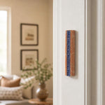 Realistic indoor scene showing Jerusalem stone mezuzah mounted on a right-hand doorpost in a home, positioned within the upper third of the doorframe.