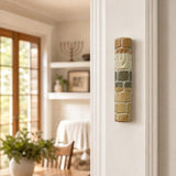 Real Jerusalem stone Mezuzah mounted vertically on a residential doorpost in a natural indoor setting.