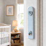 Realistic indoor scene showing New Baby Boy Mezuzah mounted on a residential doorpost beside an entryway.