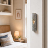 Real Jerusalem stone Mezuzah mounted on a doorpost in an indoor setting, showcasing its natural texture and horizontal lines.