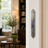 Realistic indoor scene showing the Elegant Swirls Blue Mezuzah mounted on a doorway doorpost.