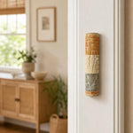 Real Jerusalem stone mezuzah mounted on a doorpost in a natural indoor setting, showing its textured layered surface and earthy tones.