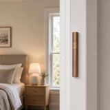 Hyper-realistic indoor scene showing a brown aluminum mezuzah mounted vertically on the right doorpost of a residential doorway, positioned within the lower third.