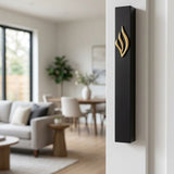 Black aluminum mezuzah mounted on a residential doorpost in a warm, inviting interior setting.