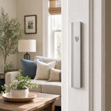 Photograph of a residential doorpost with the matte silver aluminum mezuzah mounted vertically on the right side in a home entryway.