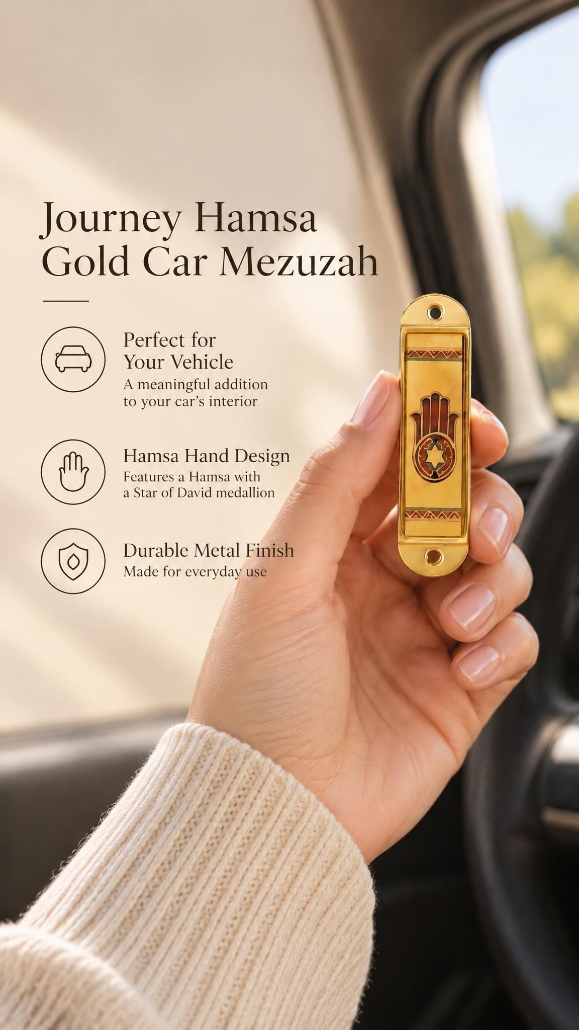 Hand holding the Journey Hamsa Gold Car Mezuzah mezuzah cover inside a vehicle, showing a brown Hamsa hand with a Star of David in its palm, warm gold-colored panels and patterned borders in a rounded stainless-steel frame beside the product name and illustrated features for this decorative Jewish travel Judaica piece